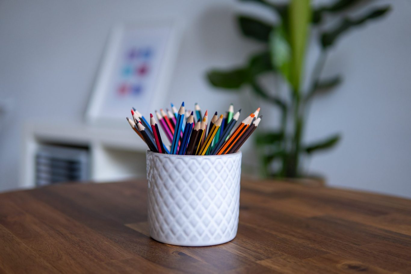 Titelbild Becher mit bunten Stiften. Behandlungszimmer im Hintergrund.